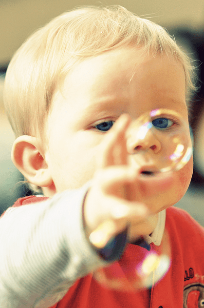 child blowing bubbles