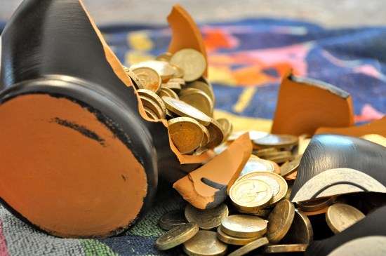 A cracked open terramundi pot with coins spilling out