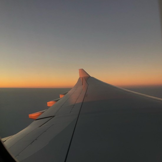A view looking along an Aeroplane wing - above the clouds and flying to Hawaii