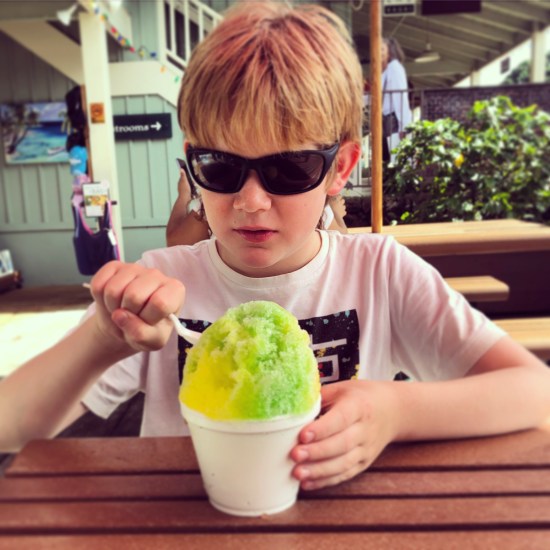 A young boy eating shave ice at Princeville Centre, Kauai, Hawaii